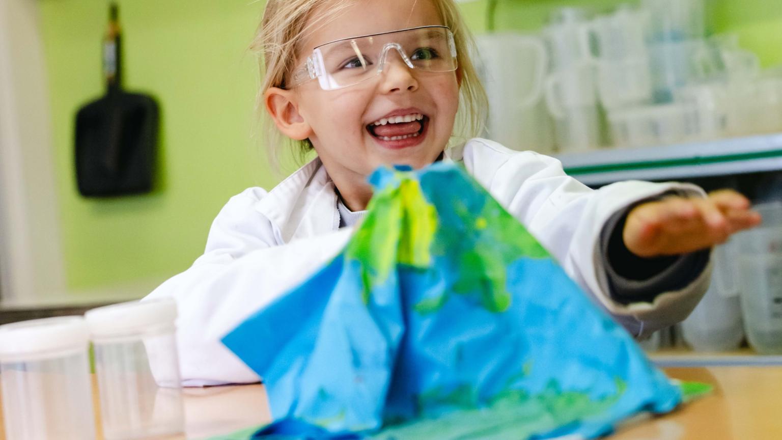 Kind met veiligheidsbril voert een proef uit tijdens een kinderfeest bij Hemlab