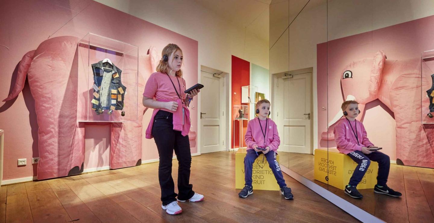 Kinderen beleven een luisterroute in een kleurrijk museum