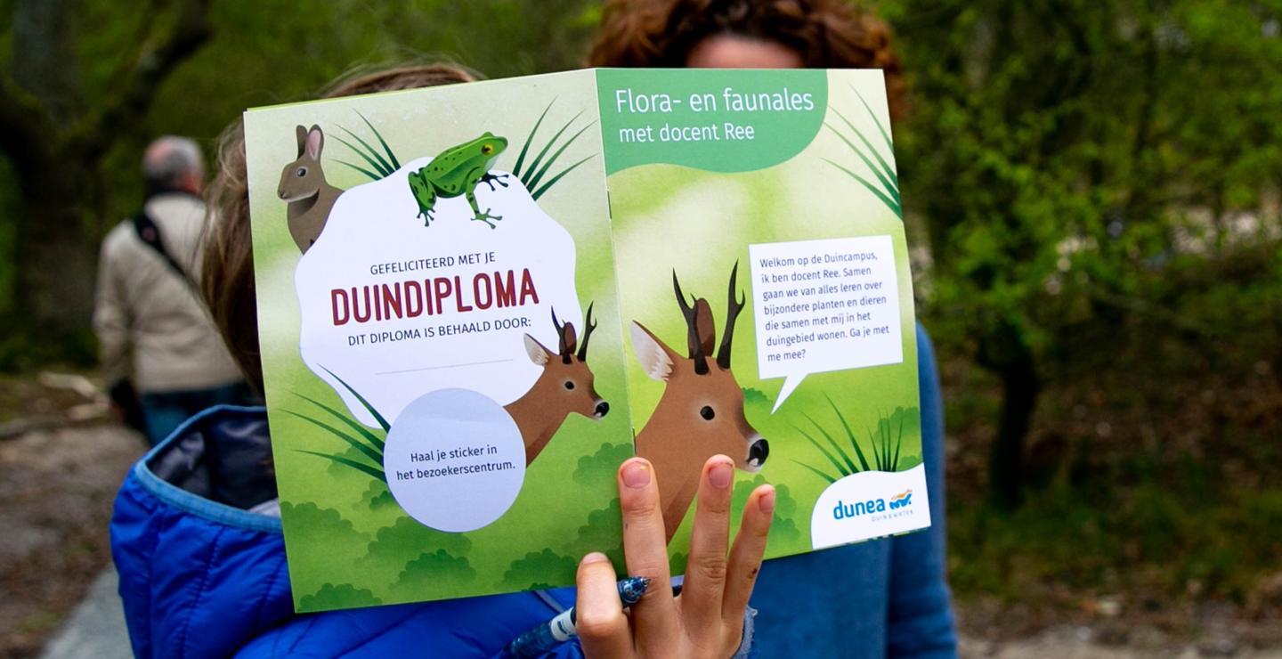 Kind houdt duindiploma omhoog