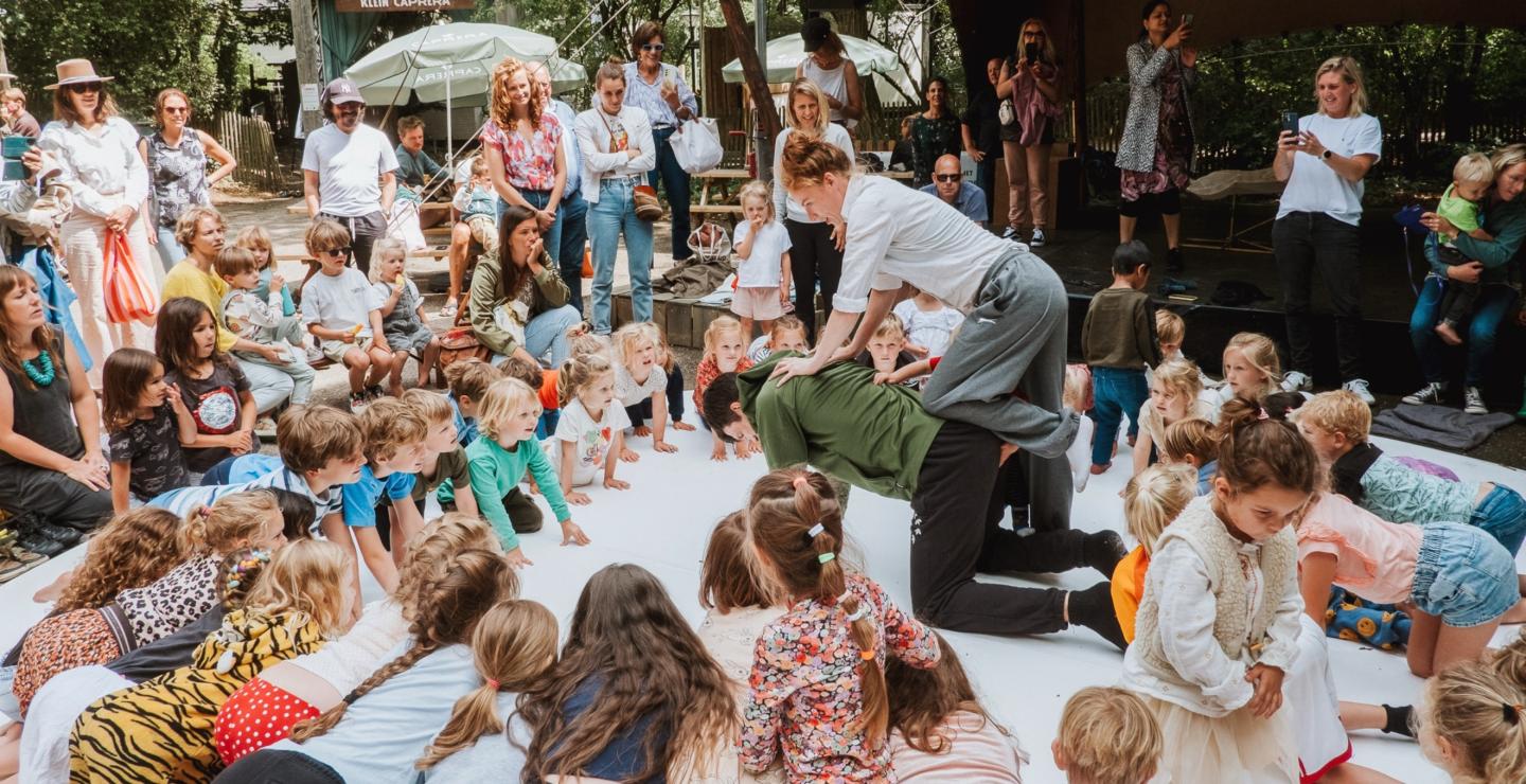 A group of children are participating in a performance at the Caprera open-air theatre