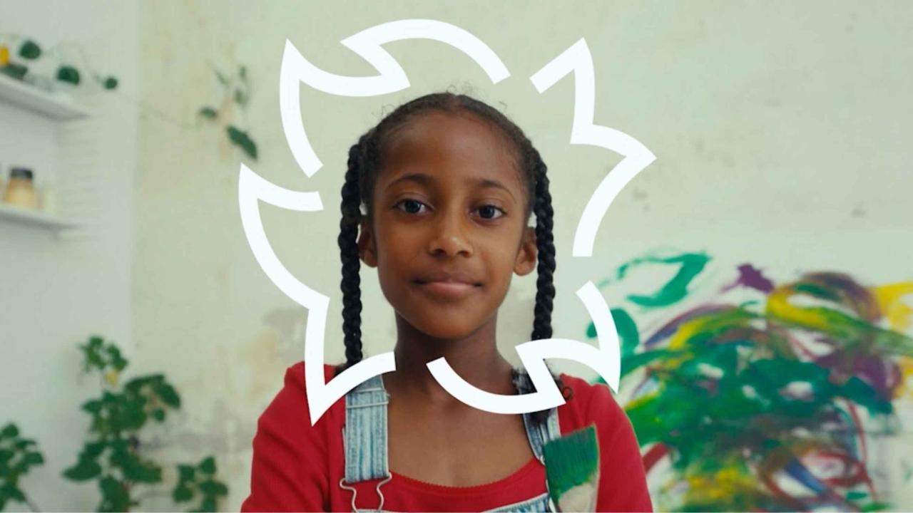Kind voor een kleurrijke achtergrond tijdens het Cinekid Festival
                