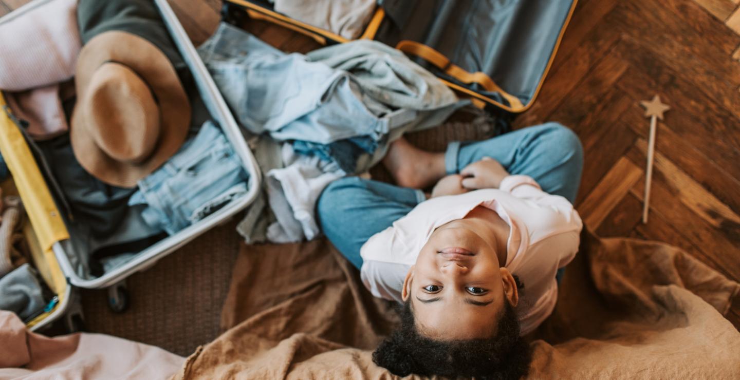 Child is sitting on the couch and is busy unpacking his suitcases