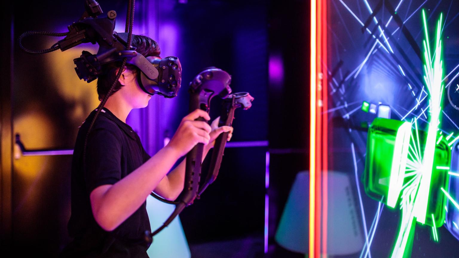 Speler met VR-headset en controllers tijdens een VR-arcade game