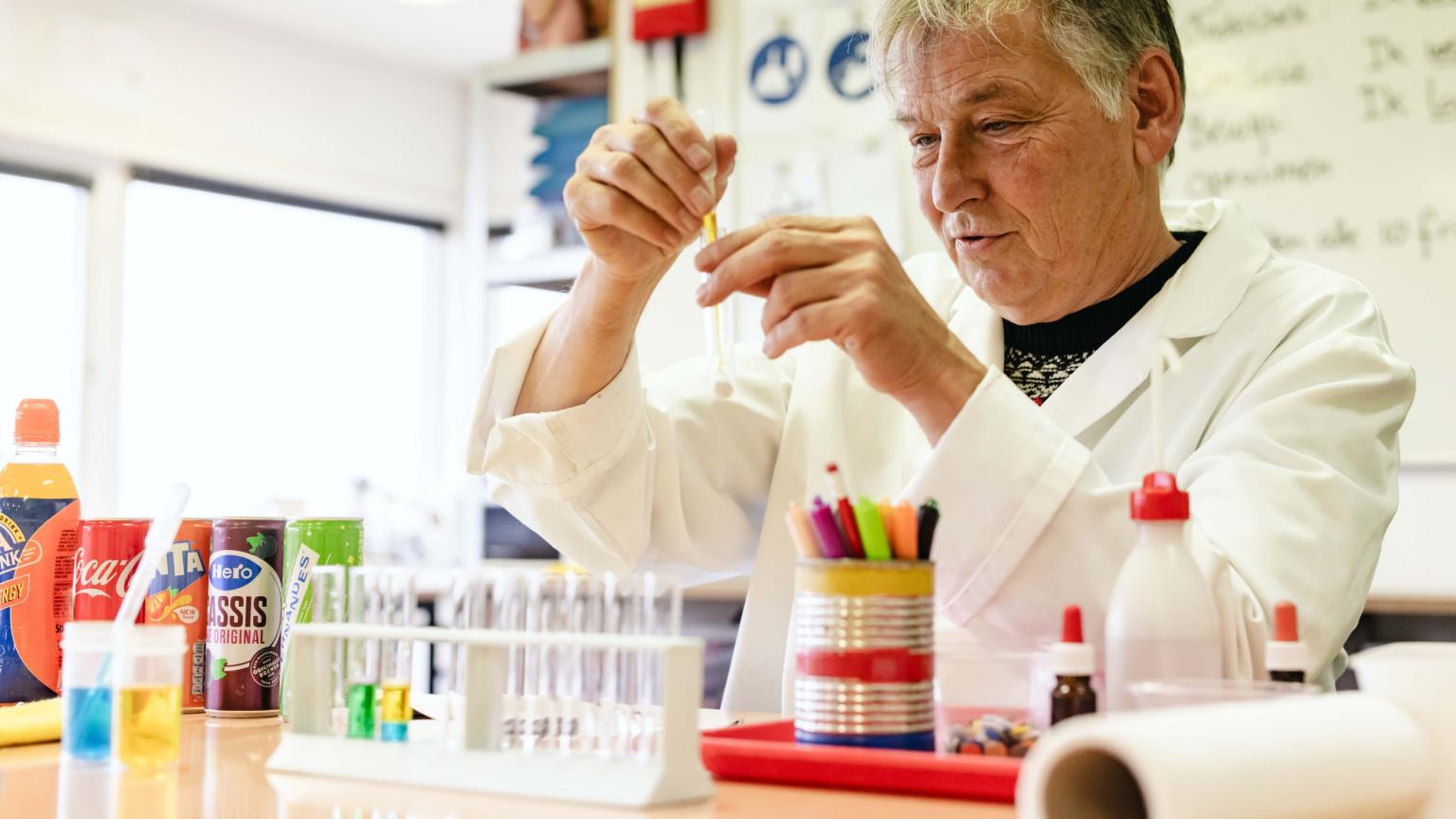 Begeleider helpt kinderen bij een wetenschappelijk experiment in het lab