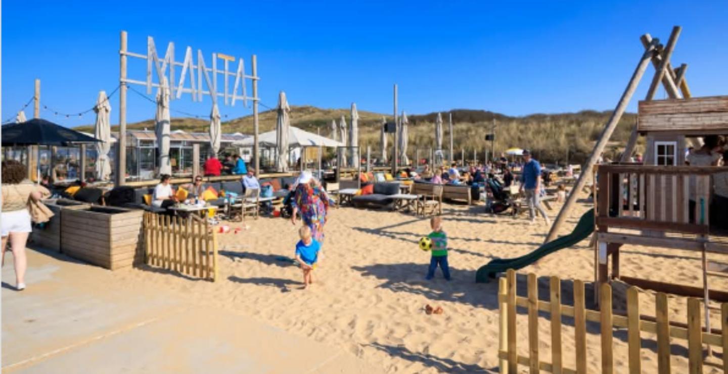 Kinderen spelen in speeltuin op het strand bij Manta Beach