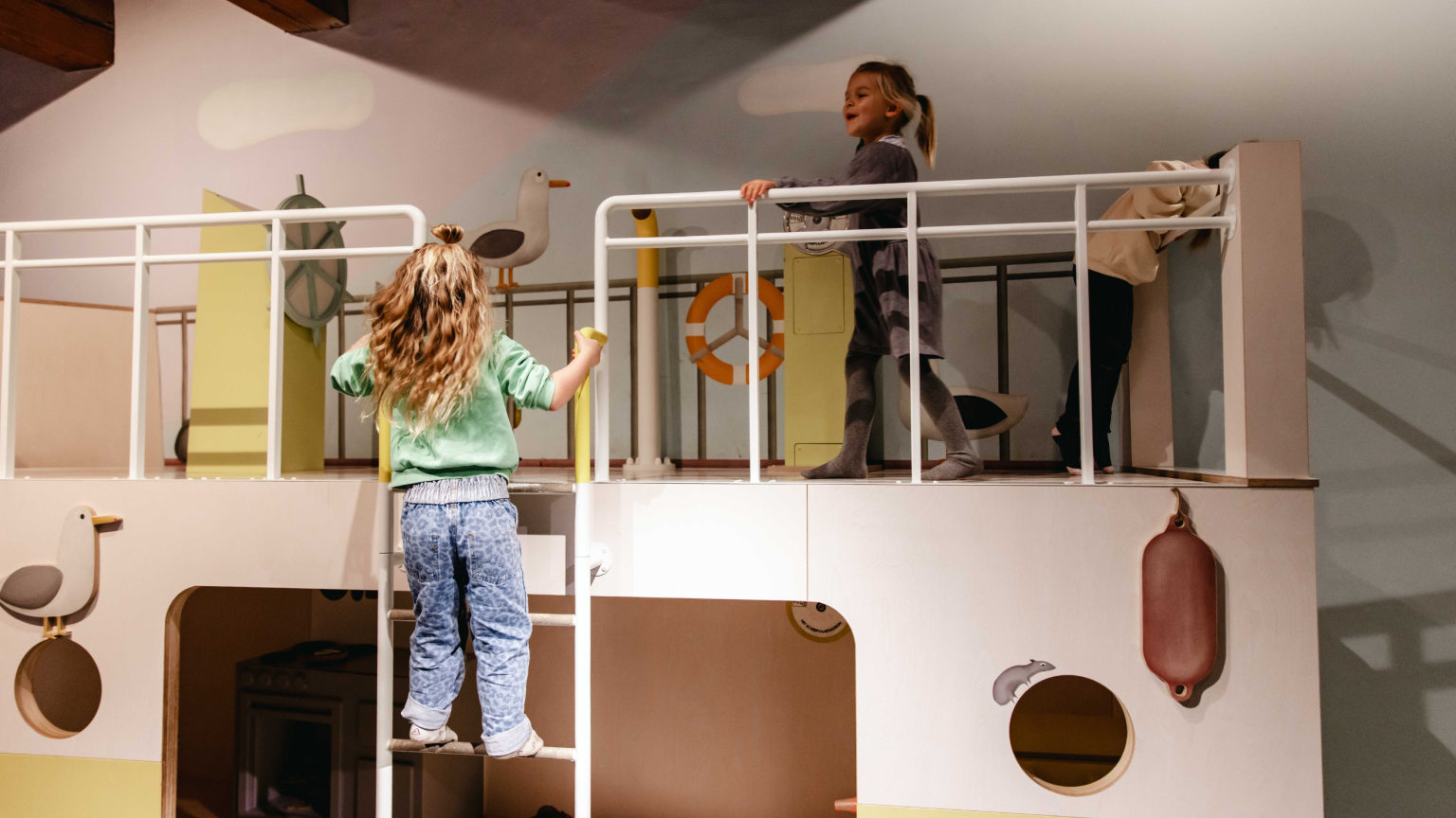 Kinderen die klimmen en spelen op een scheepsplatform in de Duiker Doris tentoonstellingsruimte