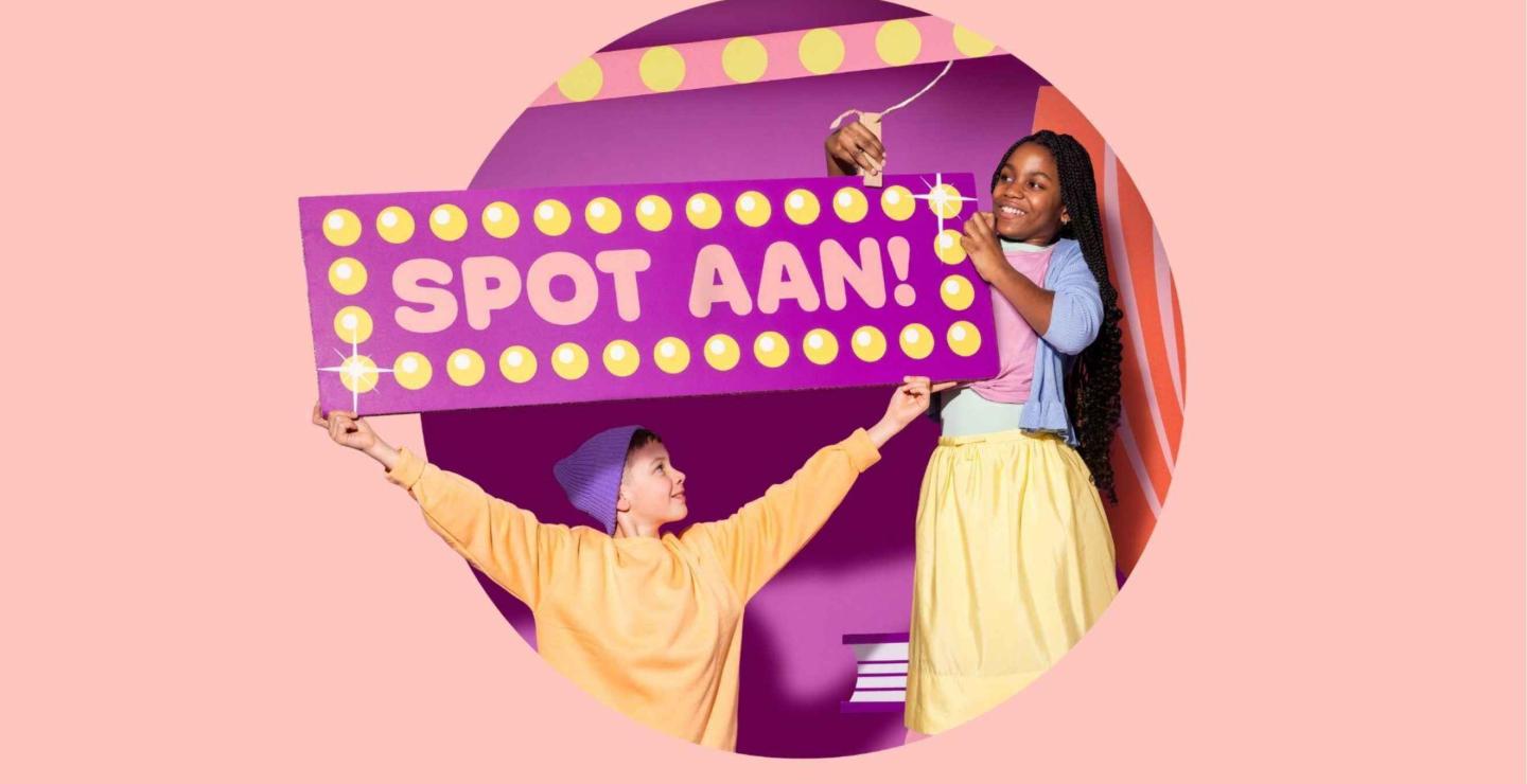 twee kinderen in een theater houden een bord imhoog met Spot aan