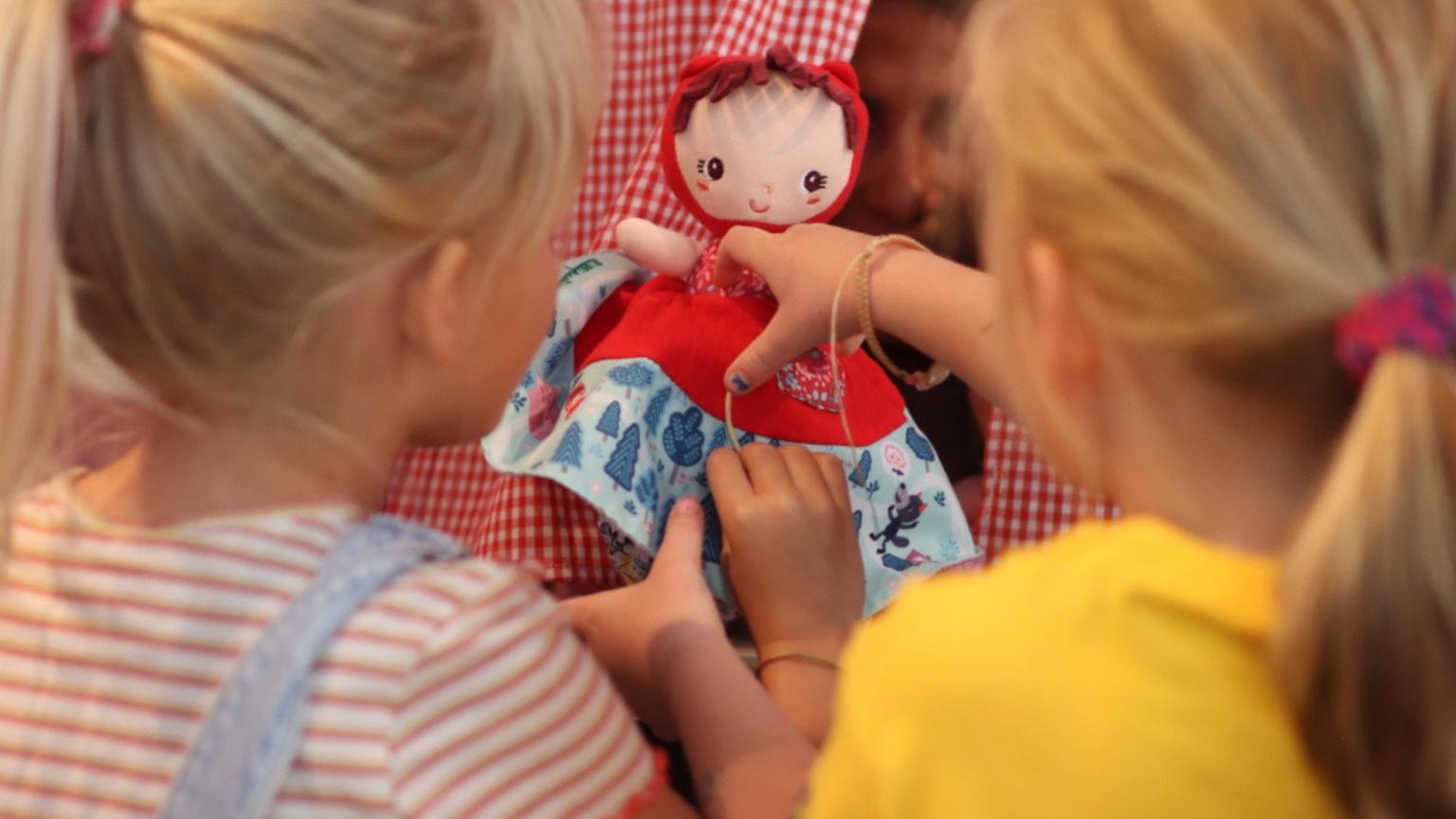 Kinderen die een pop vasthouden tijdens een speelmoment bij een poppenkast |playtix