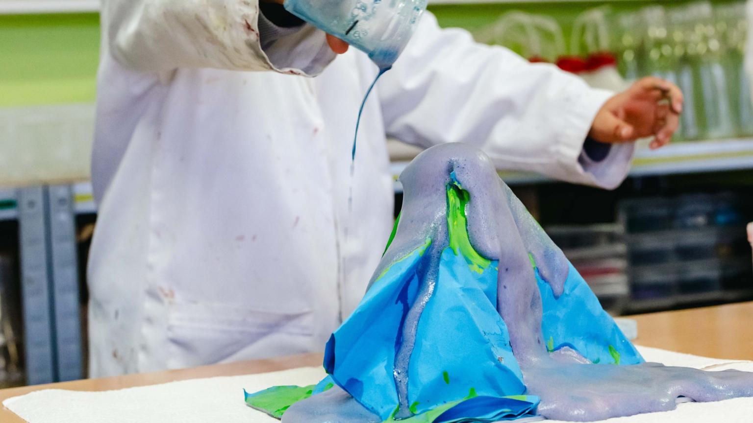 Erupting homemade volcano with colorful liquids during a kids’ lab at Hemlab