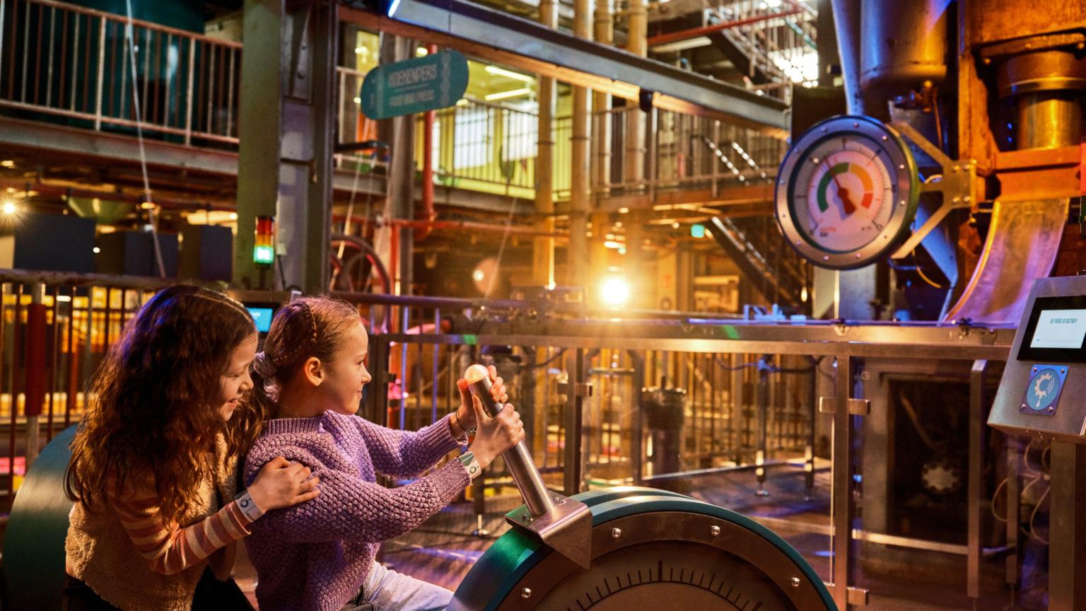 Kinderen bedienen een grote machine tijdens een interactieve missie in The Chocolate Factory