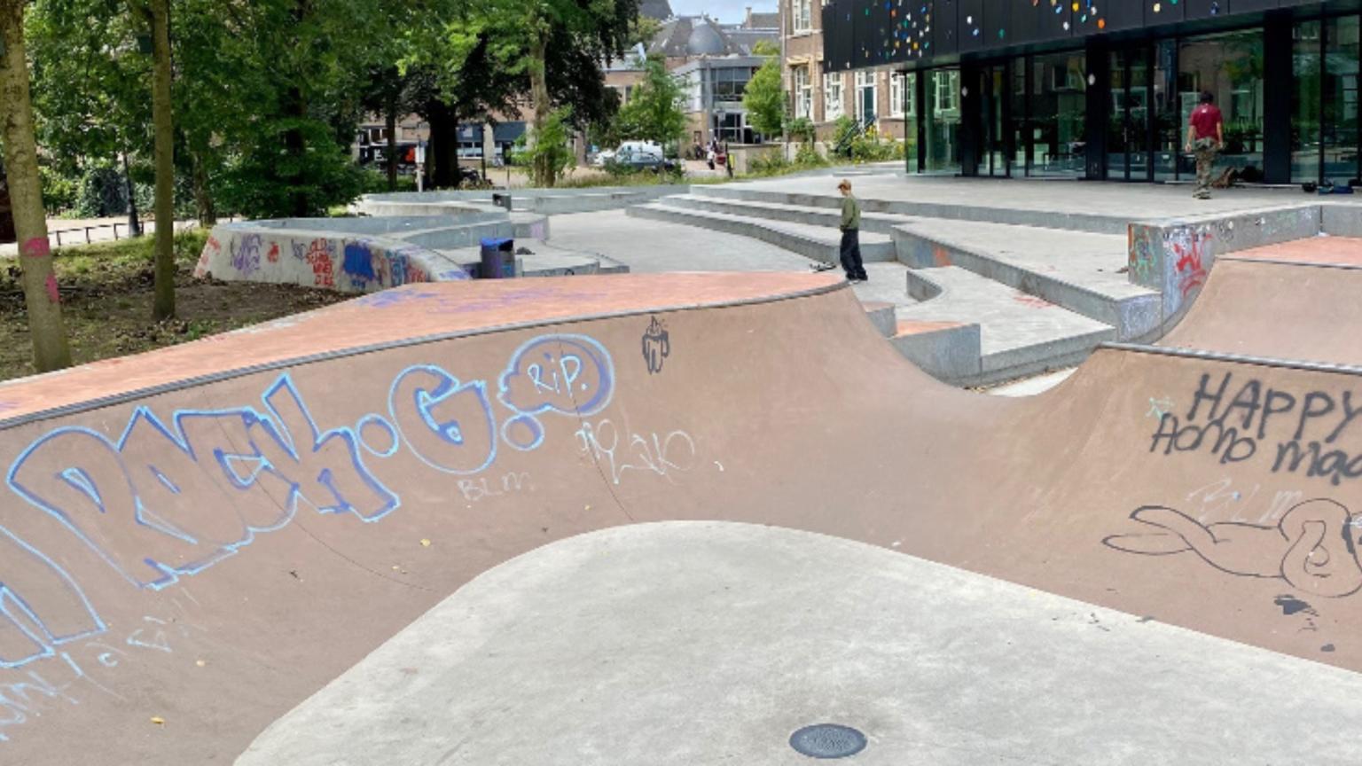 Boy stands on a skateboard in the Oosterpark skatepark