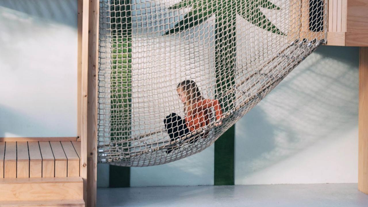 Child plays in the nets at the treehouse club in The Hague
                