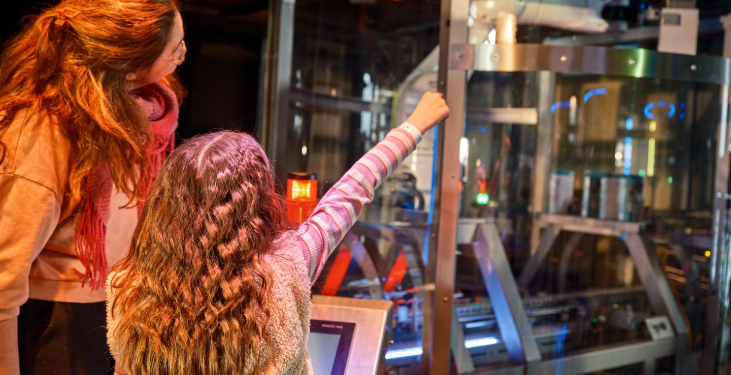 Child and parent operating a machine during the interactive experience at The Chocolate Factory in Veghel