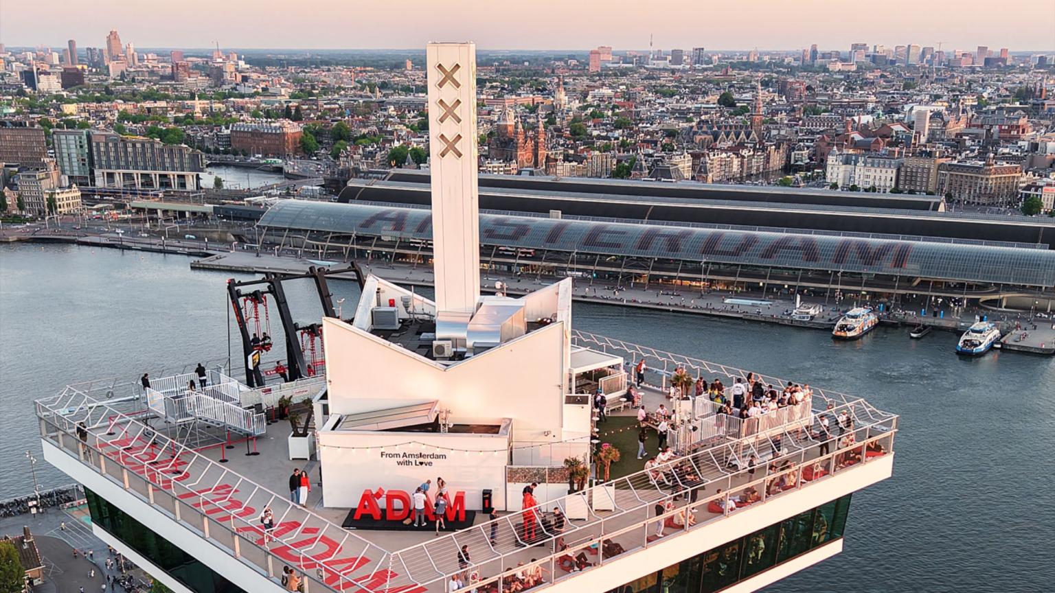 Het dakterras van A’DAM Lookout met gezinnen en uitzicht over het IJ.