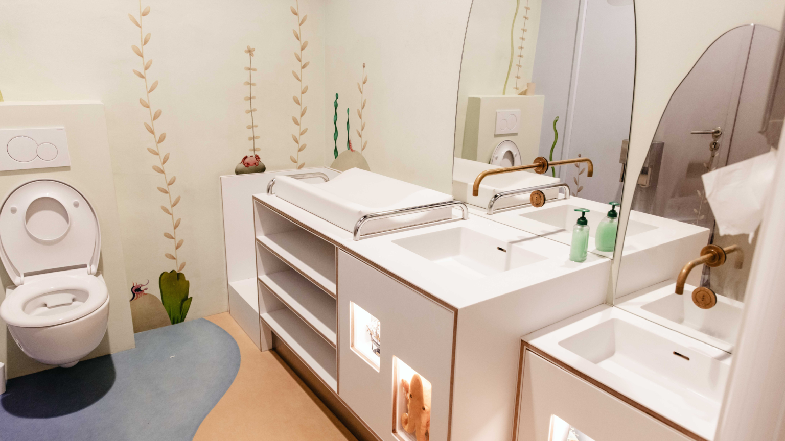 Kindvriendelijke toiletruimte met verschoonplek en speelse onderwaterillustraties.