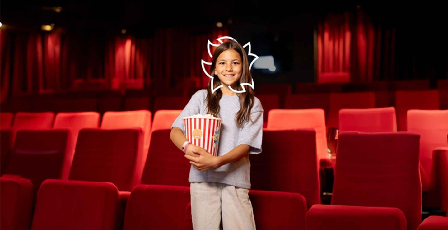 Kind met popcorn in een lege bioscoopzaal