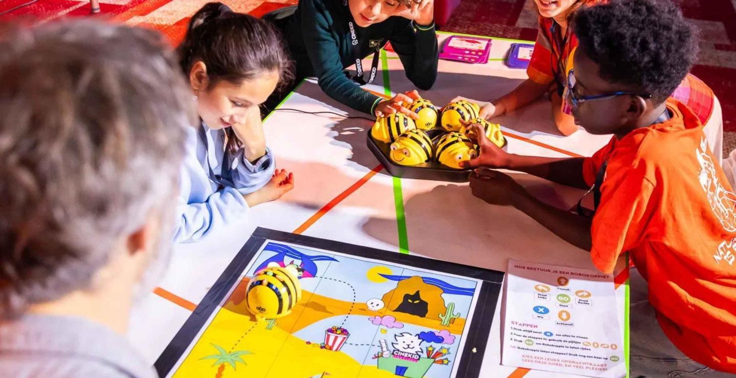 Kinderen programmeren kleine robots tijdens Robokoppies